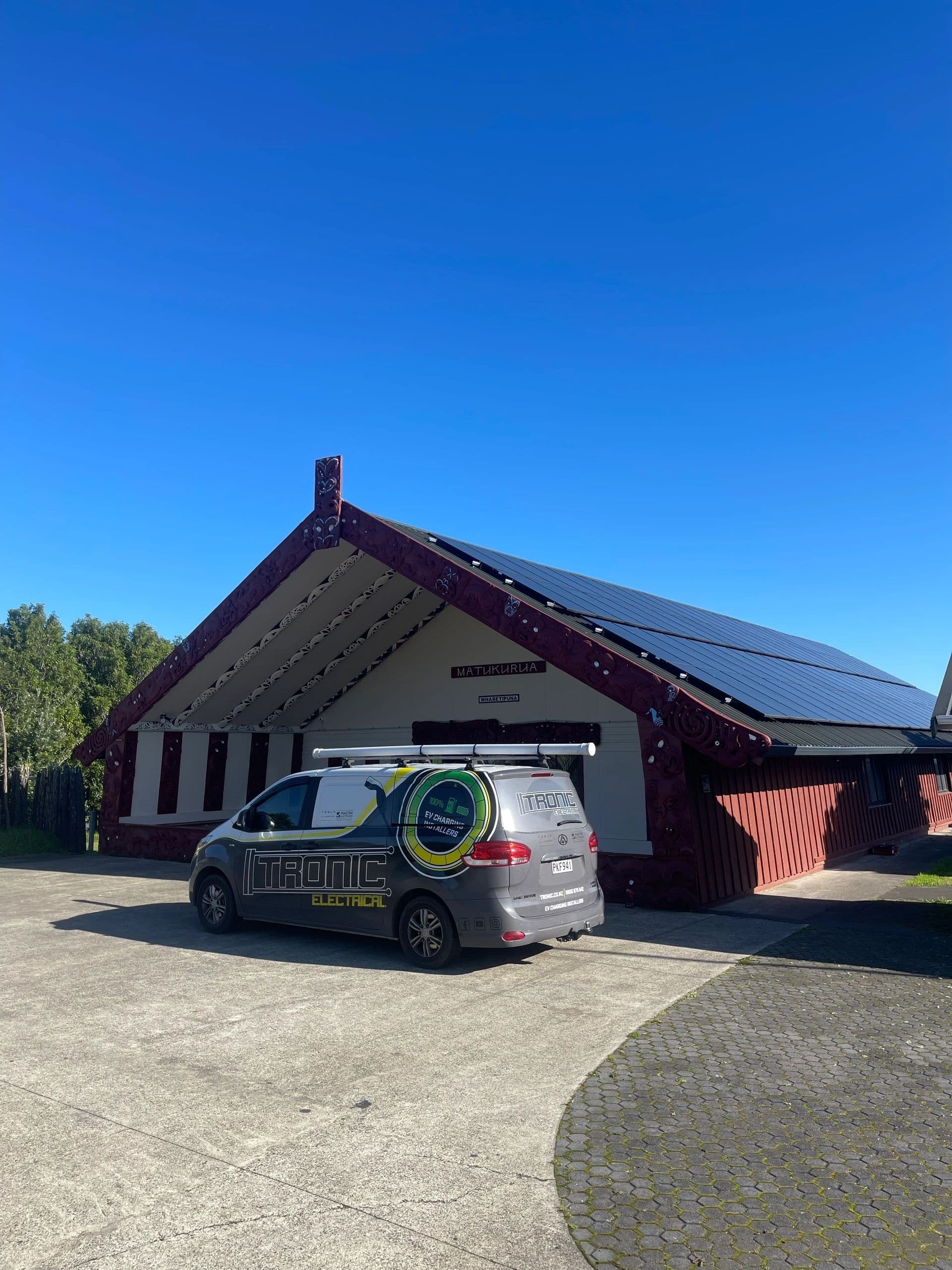 Solar panel installation on a community building with the Tronic van on site